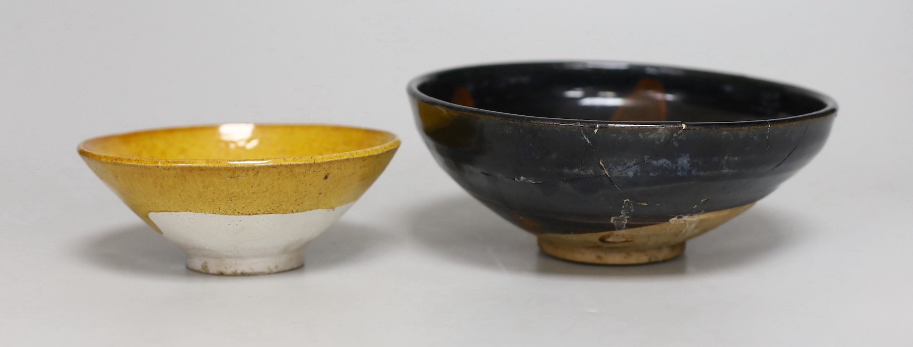 A Chinese amber-glazed pottery conical bowl with moulded floral decoration, Liao dynasty and a Cizhou black and russet glazed bowl, Song dynasty. (2) The Liao bowl from a 1980's Buckinghamshire collection